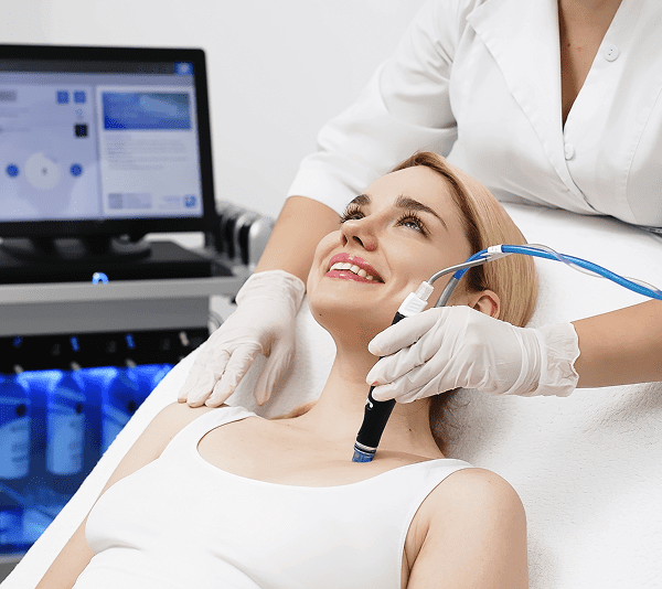 Woman receiving facial treatment in clinic.